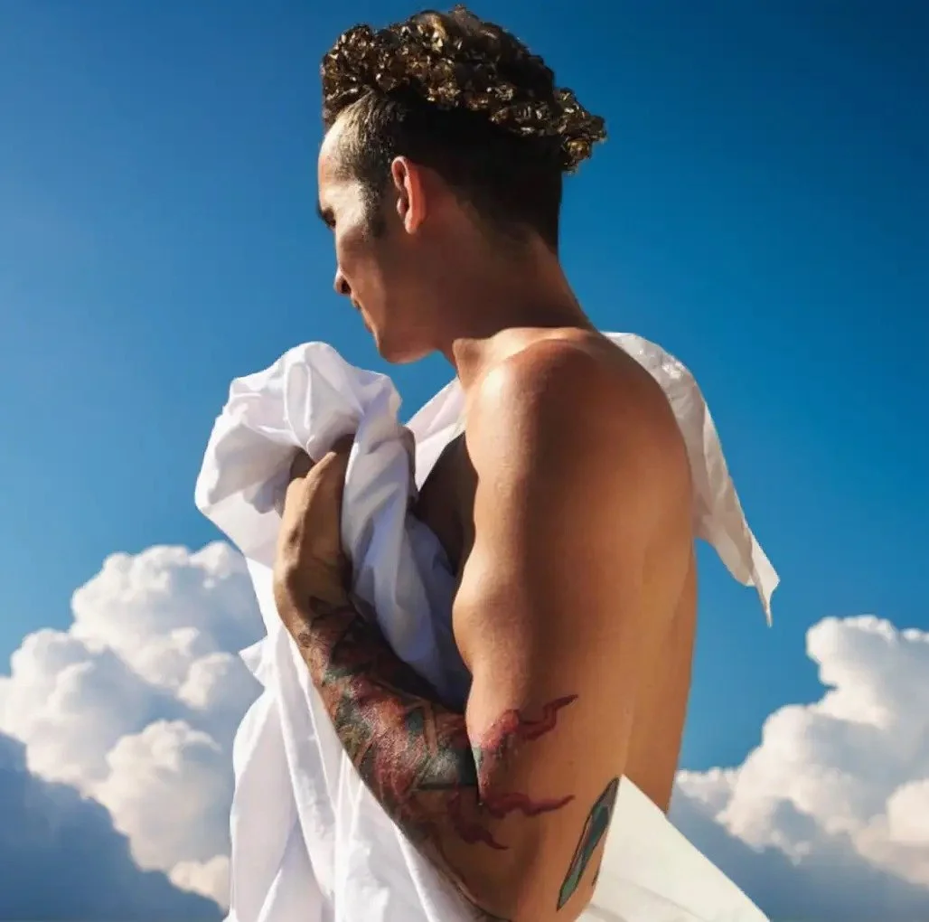 Psychic medium Dennis Valchez holding a white cloth beneath a cloudy sky.